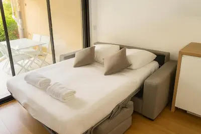 a bed with two pillows on it in a room at Beachfront 4 people 2 swimming pool in Cannes