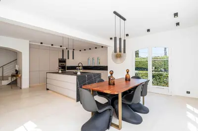 a kitchen with a wooden table and black chairs at Sumptuous villa - AC- 6BR- 12P- Cannes in Cannes
