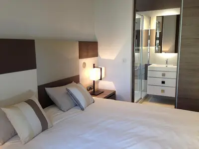 a bedroom with a large white bed and a bathroom at Cannes Croisette 4 bedrooms - 2C in Cannes