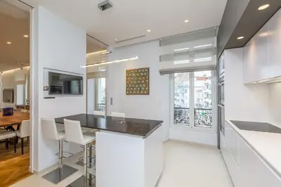 a kitchen with white walls and a table and chairs at Cannes Croisette 4 bedrooms - 2C in Cannes