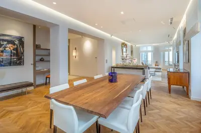 a dining room with a wooden table and white chairs at Cannes Croisette 4 bedrooms - 2C in Cannes