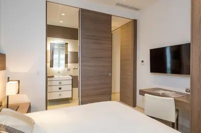 a bedroom with a bed and a desk and a television at Cannes Croisette 4 bedrooms - 2C in Cannes