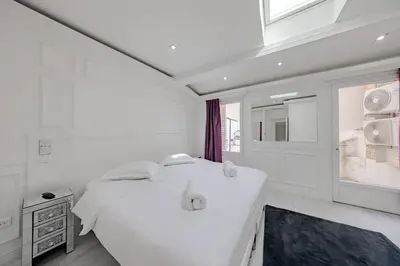 a white bedroom with a large bed and a window at Cannes 3 bedrooms apartment - 14HV in Cannes