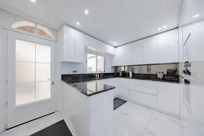 a white kitchen with white cabinets and a window at Cannes 3 bedrooms apartment - 14HV in Cannes