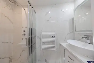 a white bathroom with a shower and a sink at Cannes 3 bedrooms apartment - 14HV in Cannes
