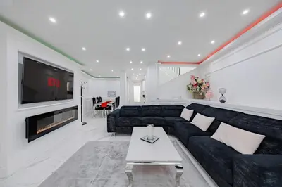 a living room with a black couch and a tv at Cannes 3 bedrooms apartment - 14HV in Cannes