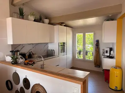 a kitchen with white cabinets and a sink at Charmante maison de village avec petite piscine privée in Le Cannet