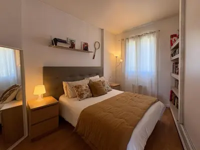 a bedroom with a bed and a book shelf at Charmante maison de village avec petite piscine privée in Le Cannet