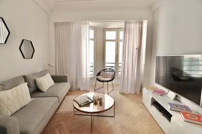 a living room with a couch and a flat screen tv at Chic 1-bedroom apartment steps away from La Croisette in Cannes