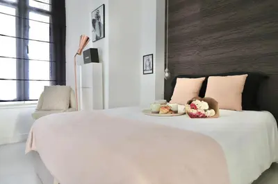 a bedroom with a bed with a plate of food on it at Chic 1-bedroom apartment steps away from La Croisette in Cannes