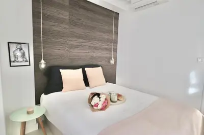a bedroom with a bed with a plate of food on it at Chic 1-bedroom apartment steps away from La Croisette in Cannes