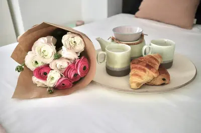 a table with a bouquet of flowers and a plate of food at Chic 1-bedroom apartment steps away from La Croisette in Cannes