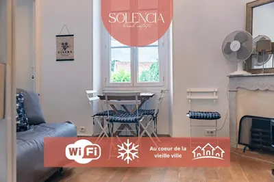 a living room with a table and chairs and a window at Au coeur du Suquet - 2 pièces cosy - Climatisation séjour in Cannes