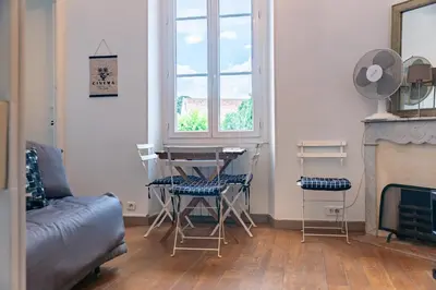 a living room with a table and chairs and a couch at Au coeur du Suquet - 2 pièces cosy - Climatisation séjour in Cannes