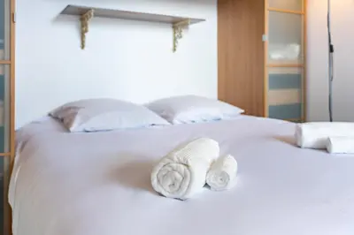 a white bed with two towels on it at Au coeur du Suquet - 2 pièces cosy - Climatisation séjour in Cannes