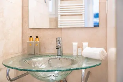 a glass sink in a bathroom with a mirror at Au coeur du Suquet - 2 pièces cosy - Climatisation séjour in Cannes