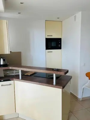 a kitchen with white cabinets and a counter top at Superbe 2 pièces à Cannes in Cannes