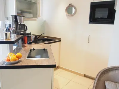 a kitchen with a sink and a bowl of fruit on a counter at Superbe 2 pièces à Cannes in Cannes