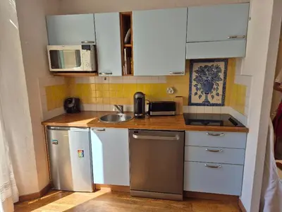 a kitchen with white cabinets and stainless steel appliances at Terrasse Bergerie in Cannes