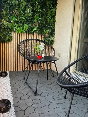 a table and a chair with flowers on a patio at T2 cosy, calme à 5 min de la Croisette in Le Cannet