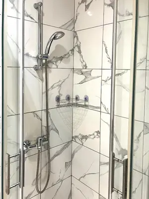 a shower in a bathroom with marble tiles at T2 cosy, calme à 5 min de la Croisette in Le Cannet