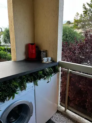 a washer and dryer in a room with a balcony at T2 cosy, calme à 5 min de la Croisette in Le Cannet