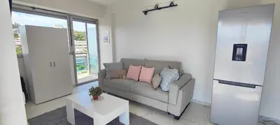 a living room with a couch and a table at Cannes Studio Vue mer Panoramique Château de la Mer in Cannes
