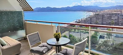 a balcony with a table and chairs and a view of the ocean at Cannes Studio Vue mer Panoramique Château de la Mer in Cannes