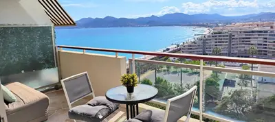 a balcony with a table and chairs and a view of the ocean at Cannes Studio Vue mer Panoramique Château de la Mer in Cannes