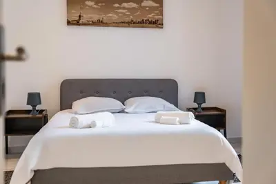 a bed with white sheets and two towels on it at 2 Pièces vieille-ville Cannes - Suquet - Proche Palais et Croisette in Cannes