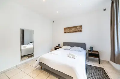 a white bedroom with a bed and a mirror at 2 Pièces vieille-ville Cannes - Suquet - Proche Palais et Croisette in Cannes