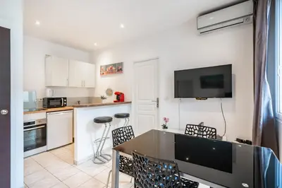 a kitchen with a table and some chairs in a room at 2 Pièces vieille-ville Cannes - Suquet - Proche Palais et Croisette in Cannes