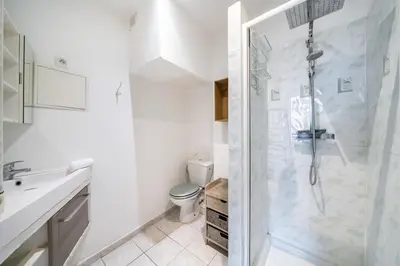 a white bathroom with a shower and a toilet at 2 Pièces vieille-ville Cannes - Suquet - Proche Palais et Croisette in Cannes