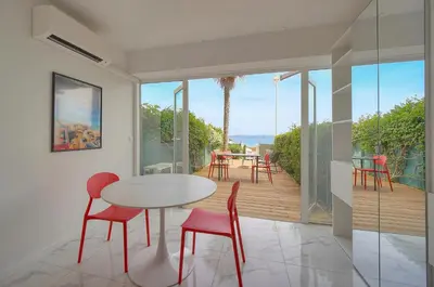 a dining room with a table and chairs on a balcony at Le Cali - Front de mer - Palm Beach - VCA in Cannes