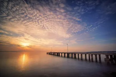 a pier on the water with a sunset in the background at Le Cali - Front de mer - Palm Beach - VCA in Cannes