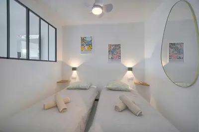 two beds in a room with a mirror at Le Cali - Front de mer - Palm Beach - VCA in Cannes