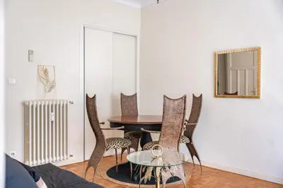 a dining room with a table and chairs and a mirror at 3 pièces centre-ville Cannes - Croisette - Climatisation séjour in Cannes