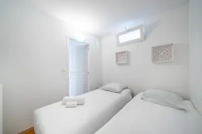 two white beds in a white room with a window at 3 pièces centre-ville Cannes - Croisette - Climatisation séjour in Cannes