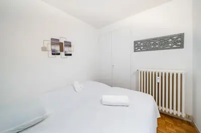 a white bedroom with a bed and a radiator at 3 pièces centre-ville Cannes - Croisette - Climatisation séjour in Cannes