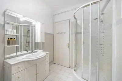 a white bathroom with a shower and a sink at 3 pièces centre-ville Cannes - Croisette - Climatisation séjour in Cannes