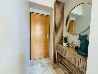 a hallway with a wooden door and a mirror at Le Sainte Rose Standing, Cannes center on foot in Cannes