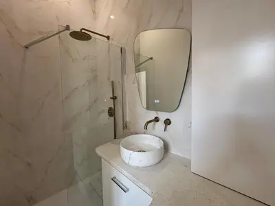 a bathroom with a sink and a shower with a mirror at Le Sainte Rose Standing, Cannes center on foot in Cannes
