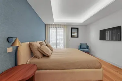 a bedroom with a large bed with a blue wall at REF 1998 - Cannes - Sea view apartment for rent in Cannes
