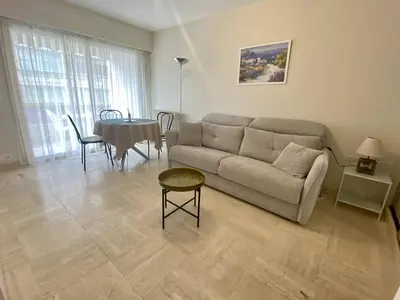 a living room with a couch and a table at Cannes proche Croisette - Studio moderne balcon in Cannes