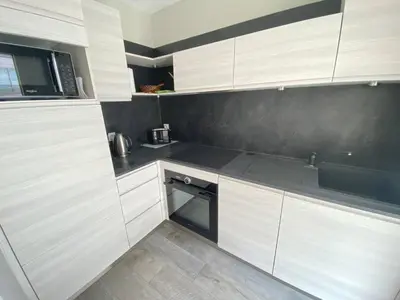 a kitchen with white cabinets and a sink at Cannes proche Croisette - Studio moderne balcon in Cannes