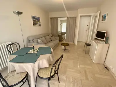 a living room with a table and a couch at Cannes proche Croisette - Studio moderne balcon in Cannes