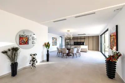 a kitchen and dining room with white walls and a dining table at Villa Dream Cannes in Cannes