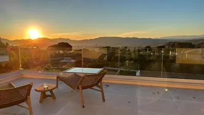 a balcony with a table and chairs and the sunset at Villa Dream Cannes in Cannes