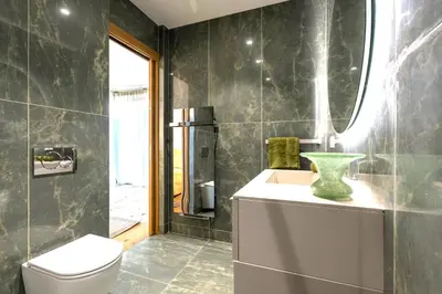 a bathroom with a toilet and a green vase on a counter at Villa Dream Cannes in Cannes