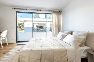 a bedroom with a large bed and a large window at Villa Dream Cannes in Cannes